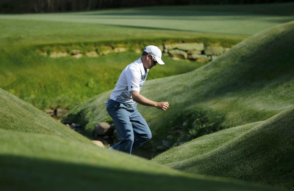 U.S. golfer Zach Johnson crosses Rae's Creek to check the 13th green before he chips on from the fairway during the second round of the Masters golf tournament at the Augusta National Golf Club in Augusta, Georgia April 11, 2014. REUTERS/Mike Blake (UNITED STATES - Tags: SPORT GOLF)