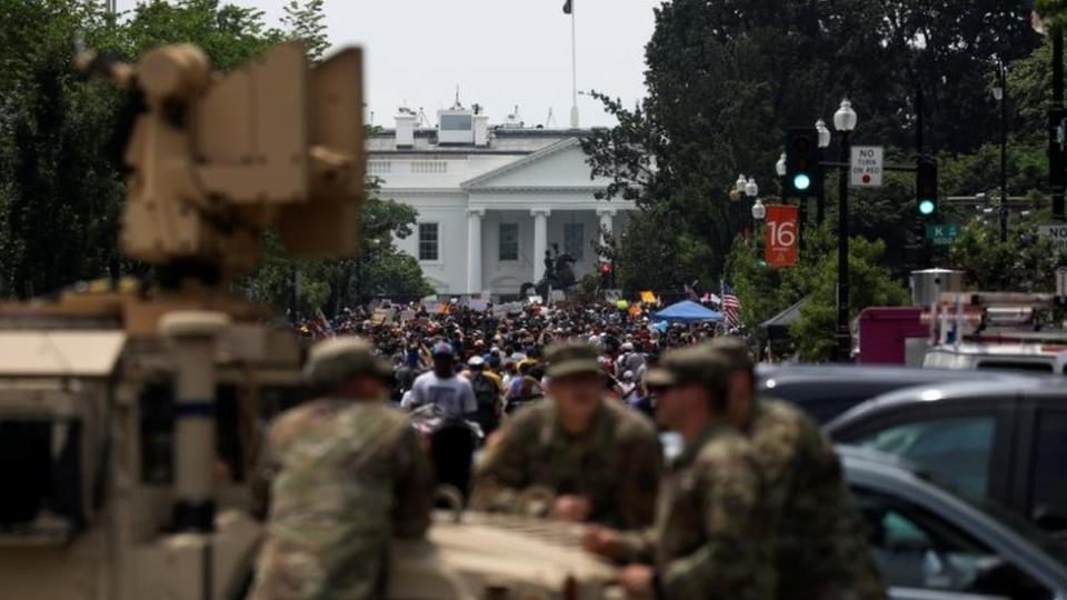 Manifestantes cerca de la Casa Blanca, en Washington D.C., siendo vigilados por soldados.