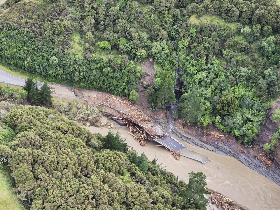 In this image released by the New Zealand Defense Force on Wednesday, Feb. 15, 2023, a road between Napier and Wairoa is washed out by flood water. The New Zealand government declared a national state of emergency Tuesday after Cyclone Gabrielle battered the country's north in what officials described as the nation's most severe weather event in years. (New Zealand Defense Force via AP)