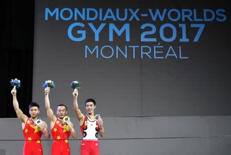 Oct 3, 2017; Montreal, Quebec, CAN; Chaopan Lin of People's Republic of China (left) and Ruoteng Xiao of People's Republic of China (center) and Kenzo Shirai of Japan (right) respectively finishes second and first and third at the Men's Individual All-Around Final during the 47th FIG Artistic Gymnastics World Championship at Montreal Olympic Stadium. Mandatory Credit: Jean-Yves Ahern-USA TODAY Sports