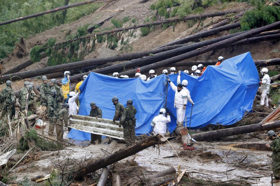 FILE - Rescuers conduct search operation at the site of a landslide in Mimata, Miyazaki Prefecture, southern Japan, Sept. 19, 2022. Typhoon Nanmadol slammed southwestern Japan. The risk of typhoons in Japan has gone up and the amount of snowfall has declined, even as the threat of heavy snowfall remains. (Kyodo News via AP, File)