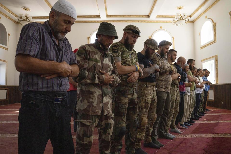 Muslim soldiers pray on the first day of Eid al-Adha, in Medina Mosque, Konstantinovka, eastern Ukraine, Saturday, July 9, 2022. Muslims around the world celebrate Eid al-Adha by sacrificing animals to commemorate the prophet Ibrahim's faith in being willing to sacrifice his son. (AP Photo/Nariman El-Mofty)