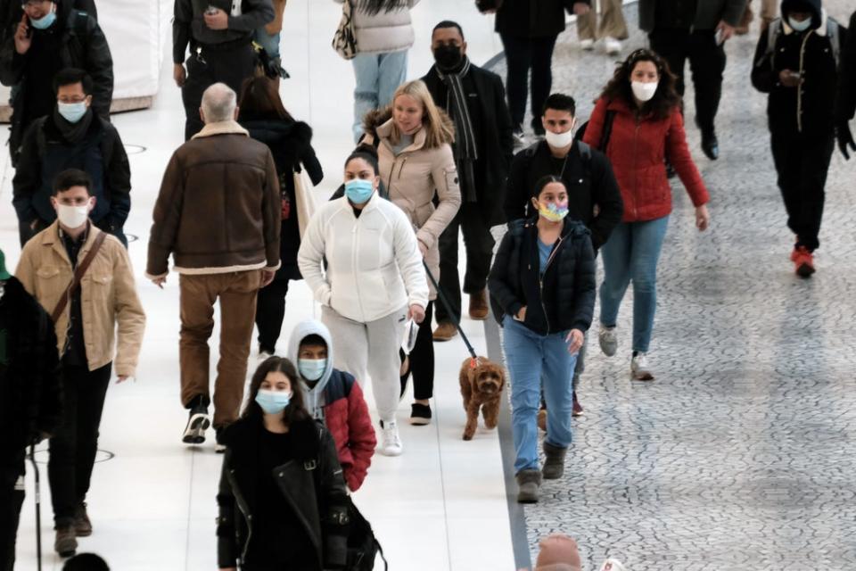 People wear masks at an indoor mall in The Oculus in lower Manhattan on the day that a mask mandate went into effect in New York on 13 December 2021 in New York City (Getty Images)