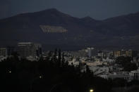 Turkish, left, and Turkish Cypriot breakaway painted giant flags are seen on Pentadahtilos mountains in the Turkish occupied area in the north, behind the divided capital Nicosia, Cyprus, Saturday, Jan. 28, 2023. Cypriots are voting Sunday for a new president who they’ll expect to decisively steer the small island nation through shifting geopolitical sands and uncertain economic times that have become people's overriding concern, eclipsing stalemated efforts to remedy the country’s ethnic division. (AP Photo/Petros Karadjias)