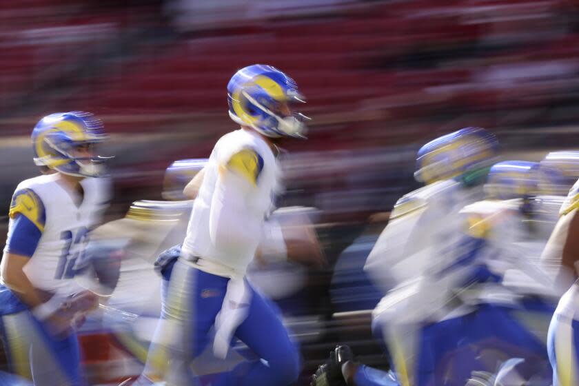 Los Angeles Rams quarterback Carson Wentz, middle, and teammates warm up before an NFL football game against the San Francisco 49ers in Santa Clara, Calif., Sunday, Jan. 7, 2024. (AP Photo/Jed Jacobsohn)