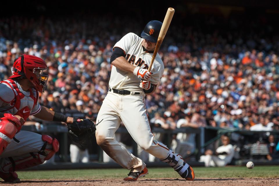 Buster Posey reacts after getting hit by a Hector Neris pitch. (Getty Images)