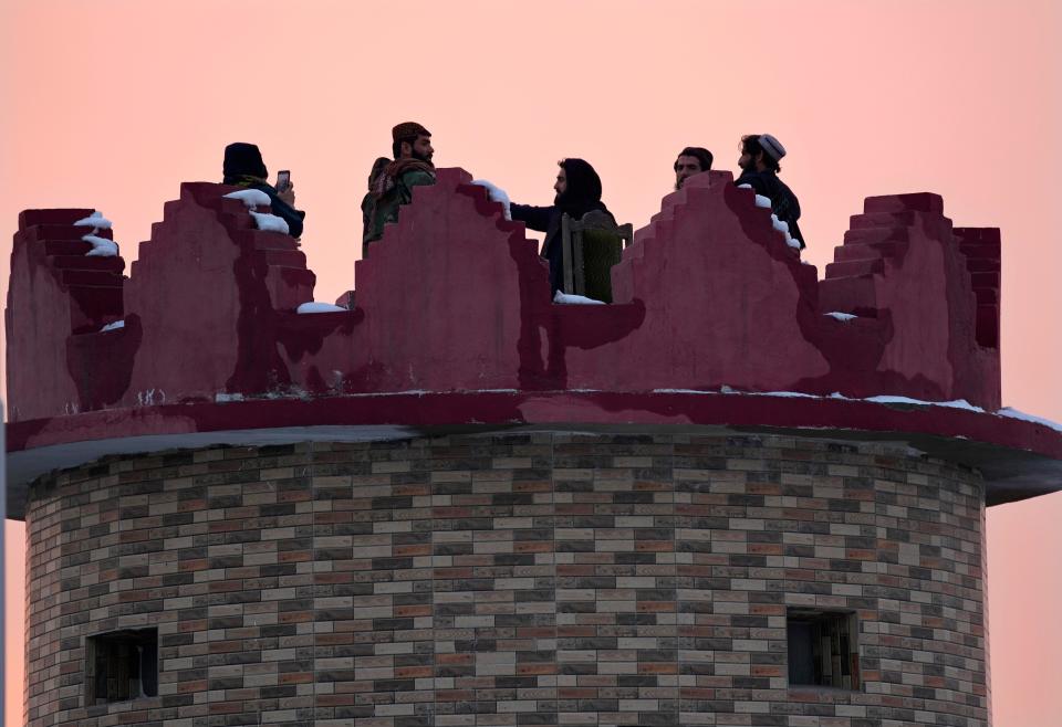 Taliban fighters watch the sunset on a tower, in Kabul, Afghanistan, Monday, Feb. 7, 2022. (AP Photo/Hussein Malla) ORG XMIT: XHM105