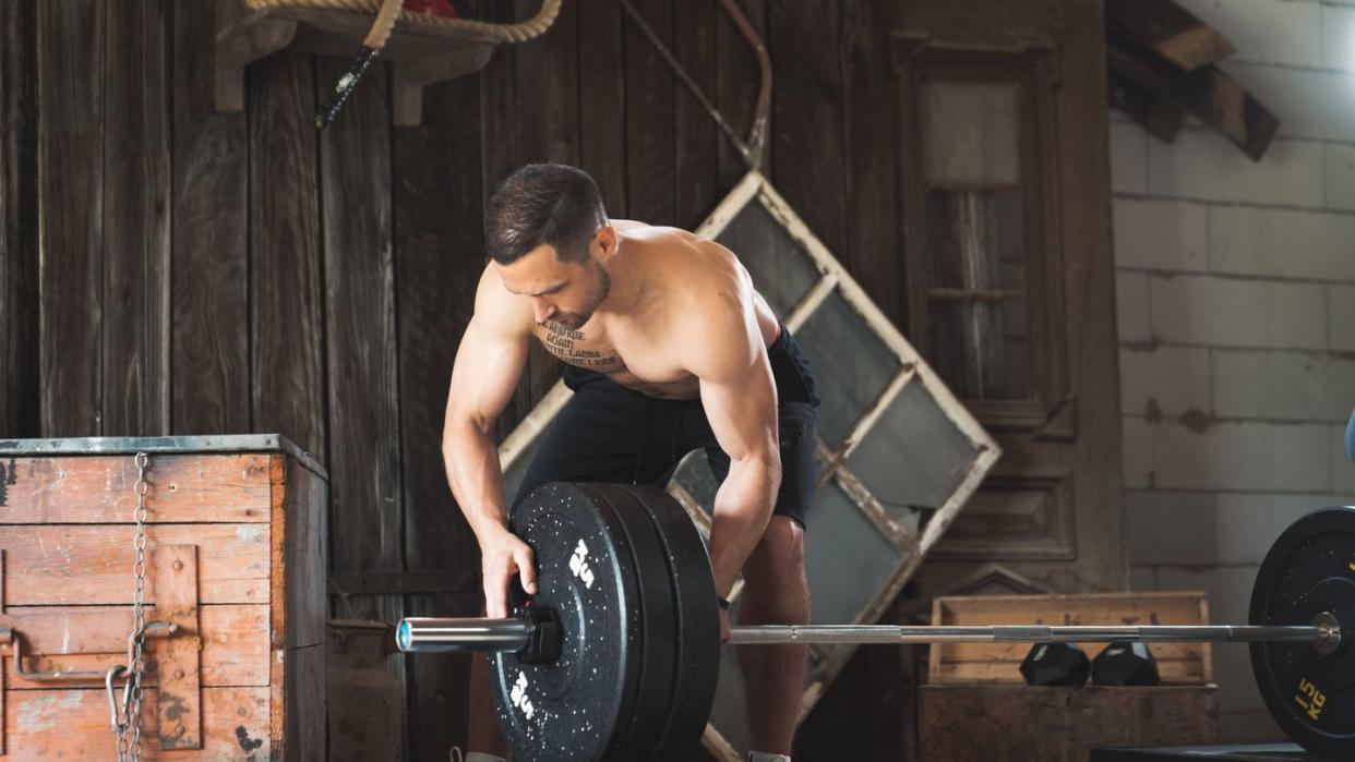 professional athlete putting weights on a barbell