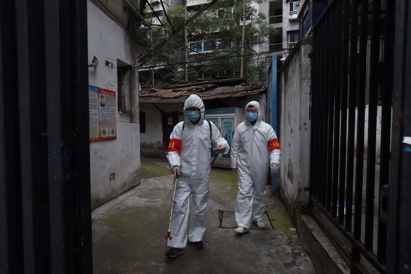 Community workers in protective suits disinfect a residential compound in Wuhan, the epicentre of the novel coronavirus outbreak