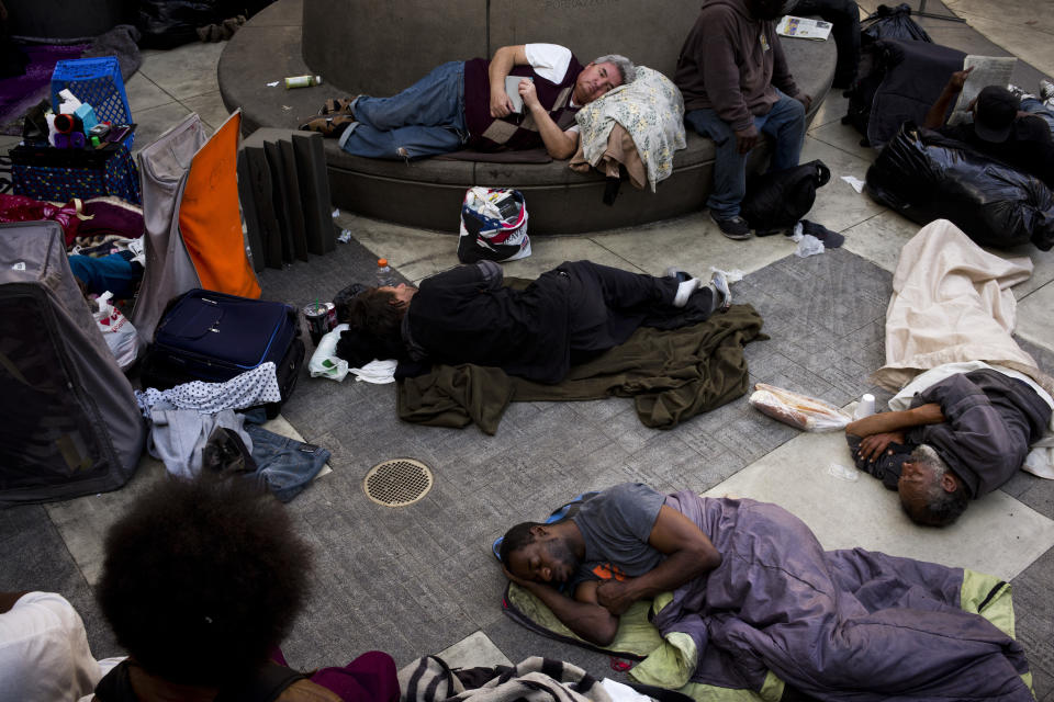 A group of homeless people sleep in the courtyard of the Midnight Mission in Los Angeles. Experts say high rent in America impacts certain cities differently. (AP Photo/Jae C. Hong)