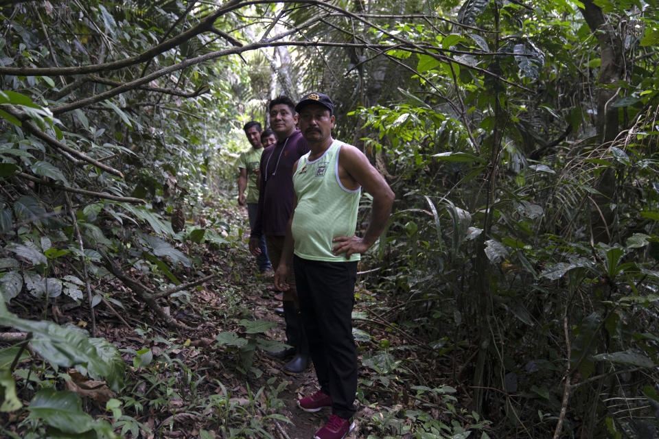 Residents of Puerto Franco community walk near to the limit of Cordillera Azul National Park, Peru, Monday, Oct. 3, 2022. Analysis by independent experts and reporting by The Associated Press raise doubts about whether a program to sell carbon credits is delivering on its promise to stop deforestation in the park and balance out carbon emissions by the companies buying the credits. (AP Photo/Martin Mejia)