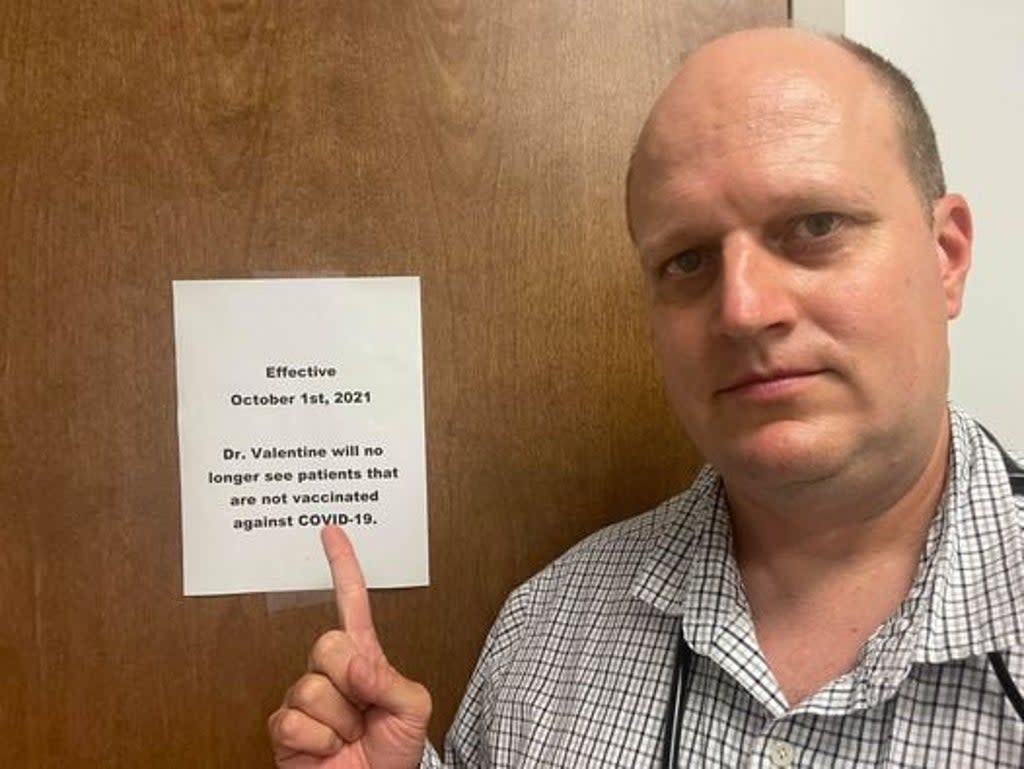 Dr Jason Valentine points to his sign requiring patients to be vaccinated.  (Jason Valentine)