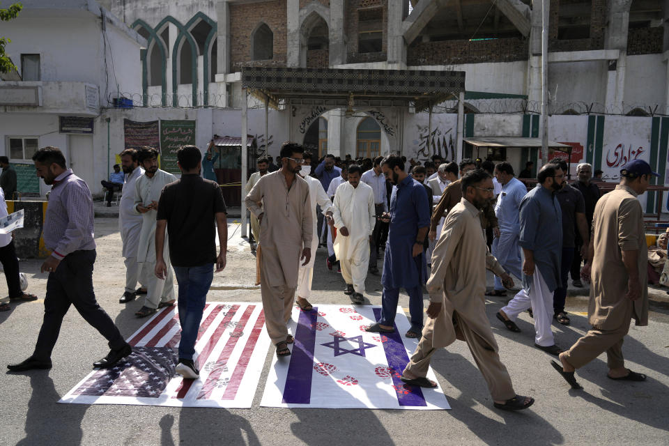 Shiite Muslims leave a mosque after Friday prayers as they walk over the representations of Israeli and U.S. flags as a protest against Israeli airstrikes on Gaza and to show solidarity with Palestinian people, in Islamabad, Pakistan, Friday, Oct. 13, 2023. (AP Photo/Anjum Naveed)