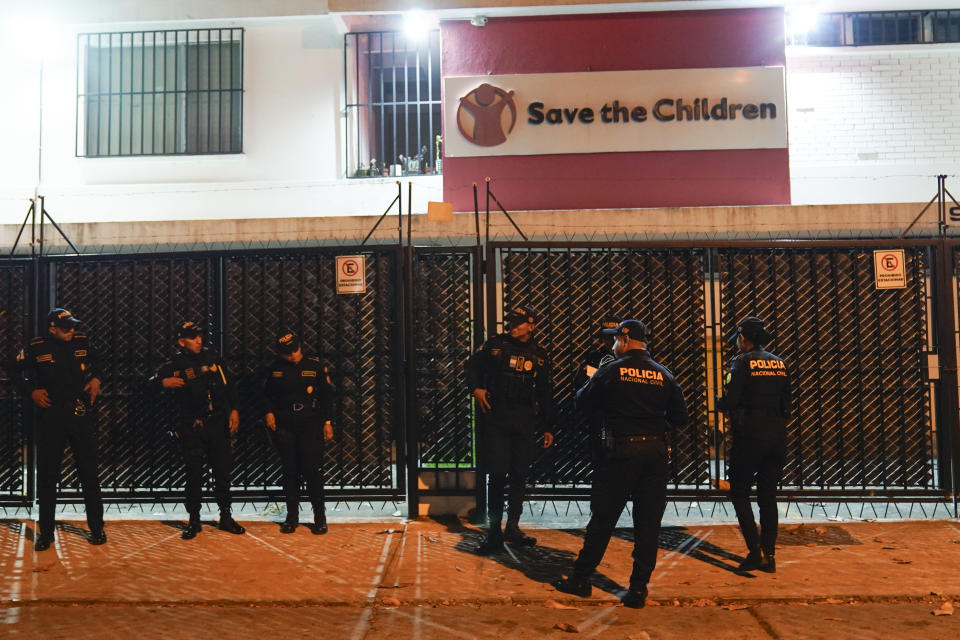 Police agents stand guard on the perimeters of the Save the Children's headquarters as agents from the Attorney General's office wind up their raid, in Guatemala City, Thursday, April 25, 2024. The NGO is being investigated for an alleged complaint about the violation of migrant children's rights, according to statements made by prosecutor Rafel Curruchiche. (AP Photo/Moises Castillo)