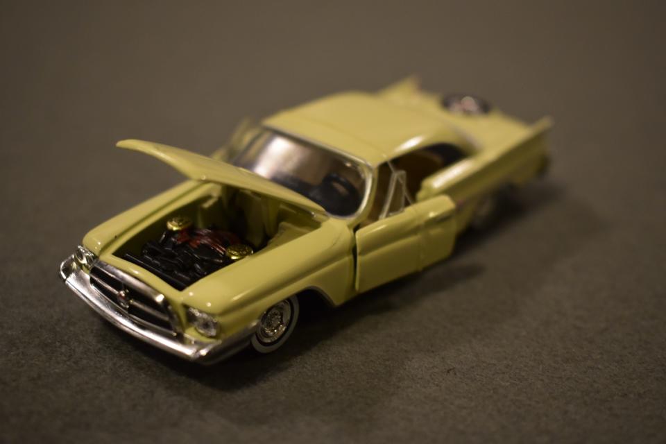 A 1/64 diecast model of a 1960 Chryser Imperial, partially in focus