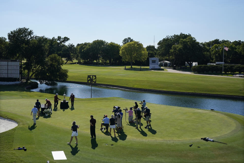 With no spectators in attendance, Daniel Berger is presented with the championship trophy in front of a small group of media after winning the Charles Schwab Challenge golf tournament after a playoff round at the Colonial Country Club in Fort Worth, Texas, Sunday, June 14, 2020. (AP Photo/David J. Phillip)