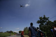 Un helicóptero de la policía mexicana sobrevuela una caravana de migrantes centroamericanos que caminan rumbo a Estados Unidos, después de que el grupo dejara Ciudad Hidalgo, México, el domingo 21 de octubre de 2018. (AP Photo/Moisés Castillo)