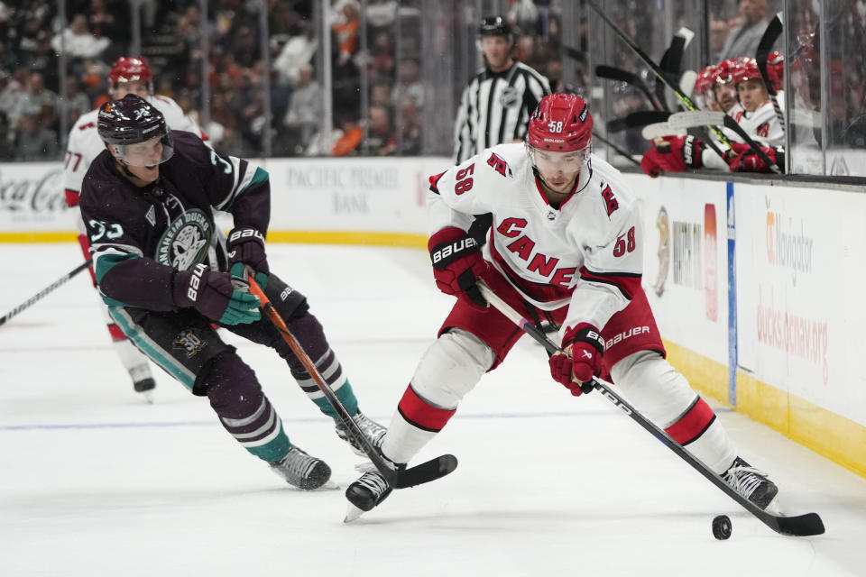 Carolina Hurricanes' Michael Bunting (58) moves the puck under pressure by Anaheim Ducks' Jakob Silfverberg during the second period of an NHL hockey game, Sunday, Oct. 15, 2023, in Anaheim, Calif. (AP Photo/Jae C. Hong)