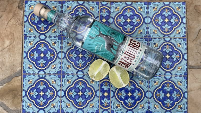 Cazadores Blanco and limes on a blue table