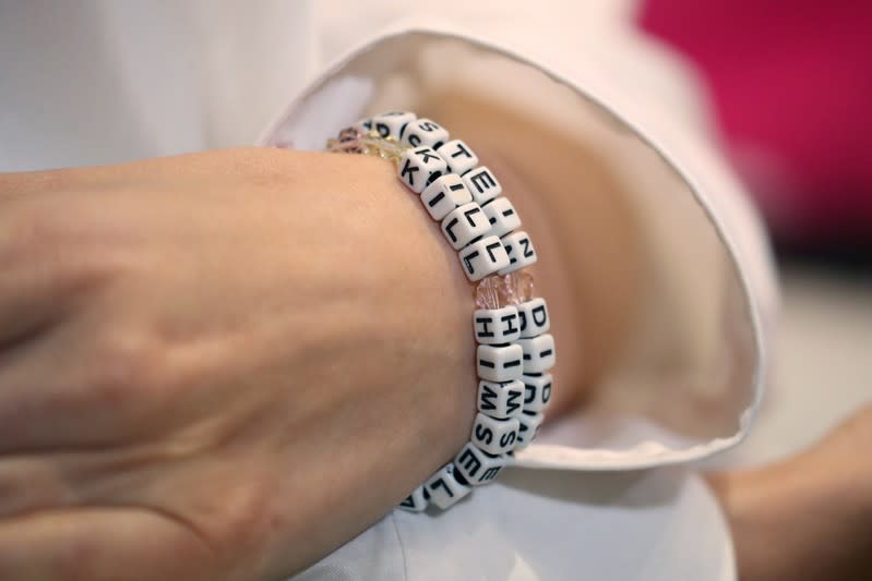 "Jane Doe 15," a 31-year-old unidentified woman, who accuses the late financier Jeffrey Epstein of sexually abusing her when she was a child, wears a bracelet that reads "Epstein didn't kill himself" as she speaks at a news conference in Los Angeles
