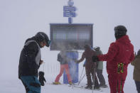 Tourists check a screen showing open ski tracks, at Plan de Corones ski area, Italy South Tyrol, Saturday, Nov. 27, 2021. After nearly two years of being restricted to watching snow accumulate on distant mountains, Italian skiers are finally returning to the slopes that have been off limits since the first pandemic lockdown in March 2020. But just as the industry is poised to recover from a lost 2020-2021 season after an abrupt closure the previous year, a spike in cases in the Alpine province bordering Austria is underlining just how precarious the situation remains. (AP Photo/Luca Bruno)