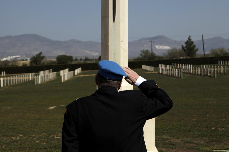 A Canadian veteran soldier who served with the United Nations Peacekeeping force on war-divided Cyprus salutes a monument dedicated to the memory of fallen British and Canadian soldiers at a cemetery inside the UN-controlled buffer zone on the outskirts of the capital Nicosia on Tuesday, March 18, 2014. Thousands of soldiers from 32 countries have donned the UN blue beret in Cyprus over half a century in what has become the longest serving peacekeeping force of its kind. Some 178 lost their lives there. (AP Photo/Petros Karadjias)