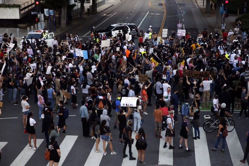 LOS ANGELES, CA - MAY 27: People take to the streets during a Black Lives Matter protest in downtown on Wednesday, May 27, 2020 in Los Angeles, CA. Several hundred protesters, many in masks, converged on downtown as part of a series of national outrage over the death of George Floyd. (Dania Maxwell / Los Angeles Times)