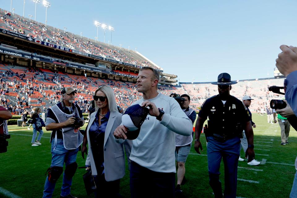 Bryan Harsin and his wife, Kes, walk off the field after Auburn's loss to Arkansas.