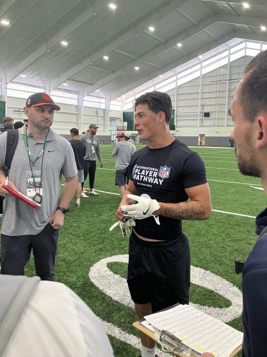 Welsh rugby star Louis Rees-Zammit, center, speaks to NFL scouts following pro day for NFL International Player Pathway prospects held at the University of South Florida on Wednesday, March 20, 2024, in Tampa, Fla. (AP Photo/Rob Maaddi)