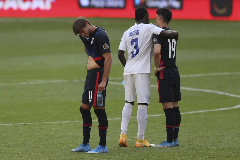 Honduras' Wesly Decas, center, comforts United States' Sebastian Soto, right, beside Ulysses Llanez at the end.