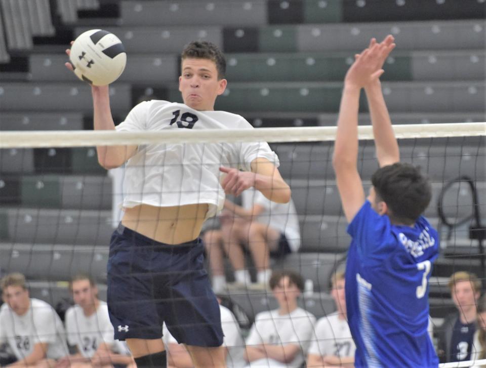 Ryland Raczka of the Poudre School District high school boys volleyball team tips the ball at the net during the new program's first-ever home match on March 30 against Fort Lupton at Fossil Ridge High School in Fort Collins.
