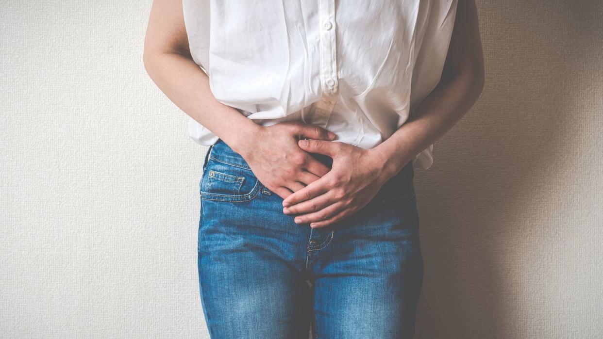 Women touching lower abdomen