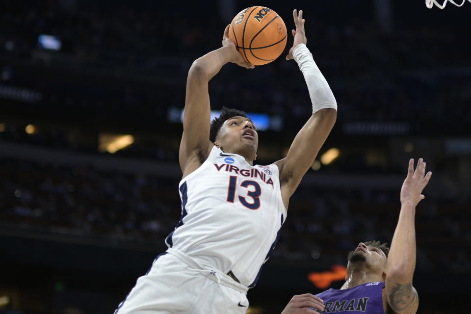 FILE - Virginia guard Ryan Dunn (13) goes up for a shot while defended by Furman forward Jalen Slawson (20) during the first half of a first-round college basketball game in the NCAA Tournament, Thursday, March 16, 2023, in Orlando, Fla. (AP Photo/Phelan M. Ebenhack, File)