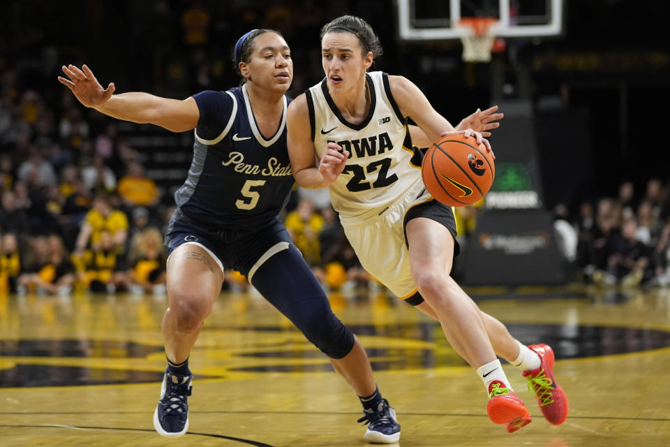 Iowa guard Caitlin Clark (22) drives to the basket past Penn State guard Leilani Kapinus (5) during the second half of an NCAA college basketball game, Thursday, Feb. 8, 2024, in Iowa City, Iowa. Iowa won 111-93. (AP Photo/Charlie Neibergall)