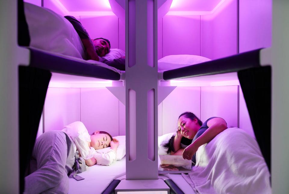 People rest on bunk beds, bathed in purple light