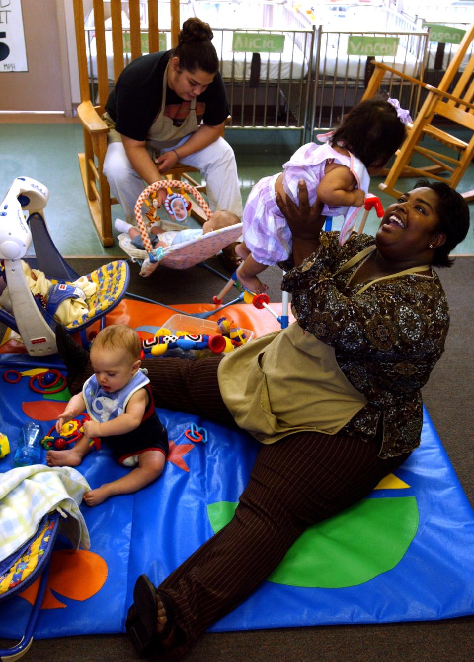 Renee Harris smiles at 6 month-old Krysenia as she and Casandra Luz tend to their little charges at Day Nursery of Abilene on Cedar Street in 2005.