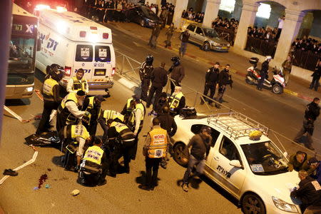 Members of Zaka Rescue and Recovery team check the body of a Palestinian attacker at the scene in Jerusalem, December 6, 2015. REUTERS/Ronen Zvulun