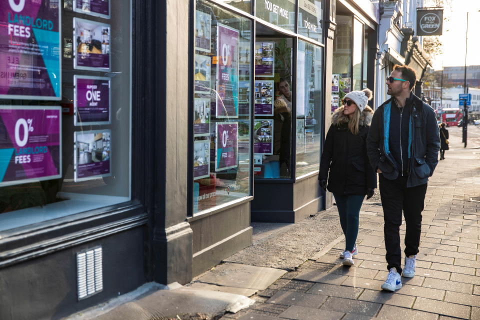 People walk past a branch of Chestertons estate agents in Islington, London, UK