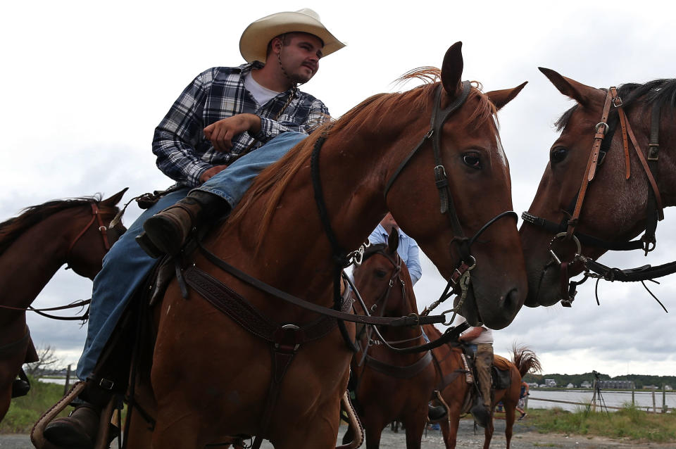 ASSATEAGUE ISLAND, VA - JULY 21: Saltwater cowboys prepare to round up wild ponies and heard them to a holding pen before making next weeks annual swim across the Assateague Channel to Chincoteague Island, on July 21, 2012 in Assateague Island, Virginia. Each year the wild ponies are auctioned off by the Chincoteague Volunteer Fire Company. (Photo by Mark Wilson/Getty Images)