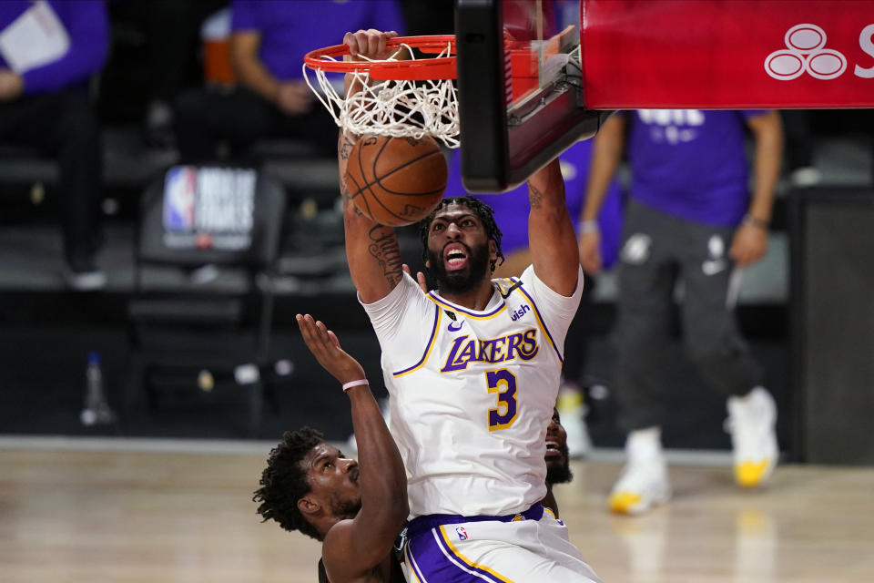 Los Angeles Lakers' Anthony Davis (3) dunks against Miami Heat's Jimmy Butler (22) and Jae Crowder (99) during the first half in Game 6 of basketball's NBA Finals Sunday, Oct. 11, 2020, in Lake Buena Vista, Fla. (AP Photo/Mark J. Terrill)