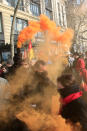 A protester holds an orange flare during a demonstration, Friday, Jan. 24, 2020 in Paris. French unions are holding last-ditch strikes and protests around the country Friday as the government unveils a divisive bill redesigning the national retirement system. (AP Photo/Michel Euler)