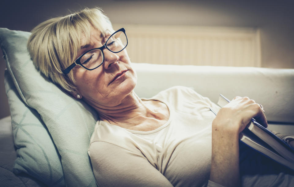 Senior woman dreaming and holding book. Close up.