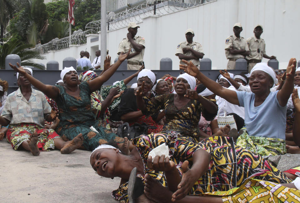 FILE - In this Dec. 19, 2011 file photo shot by AP contributing photographer John Bompengo, women supporters of opposition leader Etienne Tshisekedi protest the results of Congo's recent presidential election outside the United States embassy in Kinshasa, Democratic Republic of Congo. Relatives say longtime Associated Press contributor John Bompengo has died of COVID-19 in Congo's capital. Bompengo, who had covered his country's political turmoil over the course of 16 years, died Saturday, June 20, 2020 at a Kinshasa hospital. (AP Photo/John Bompengo, file)