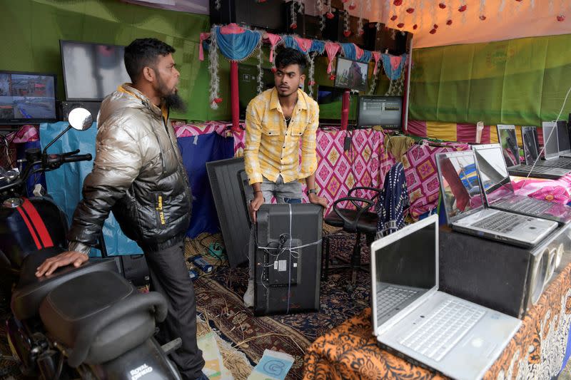 Sariful Laskar packs an old TV at a stall in a makeshift market in South Bishnupur