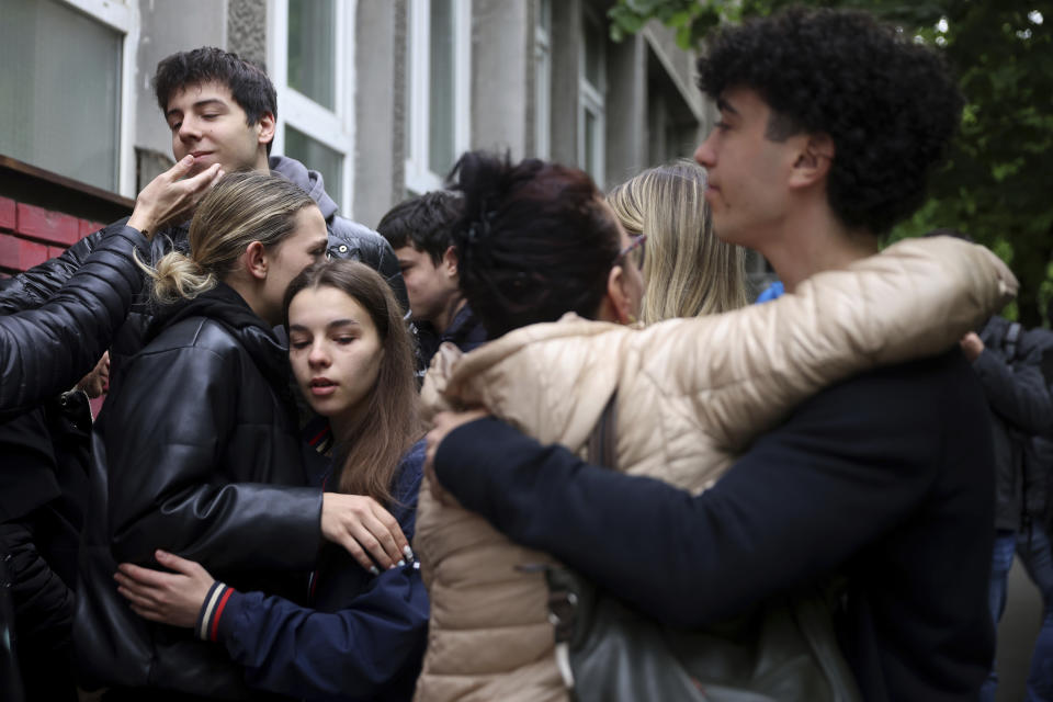 Un grupo de personas lloran las víctimas de una masacre en la escuela Vladislav Ribnikar, en Belgrado, Serbia, el 4 de mayo de 2023. (AP Foto/Armin Durgut)