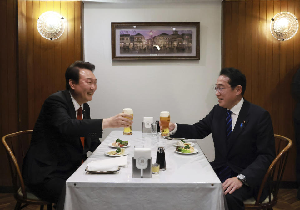 In this photo provided by Japan's Cabinet Public Affairs Office, South Korean President Yoon Suk Yeol, left, and Japanese Prime Minister Fumio Kishida make a toast at Rengatei restaurant in the famed Ginza district of Tokyo, Thursday, March 16, 2023. (Japan's Cabinet Public Affairs Office via AP)