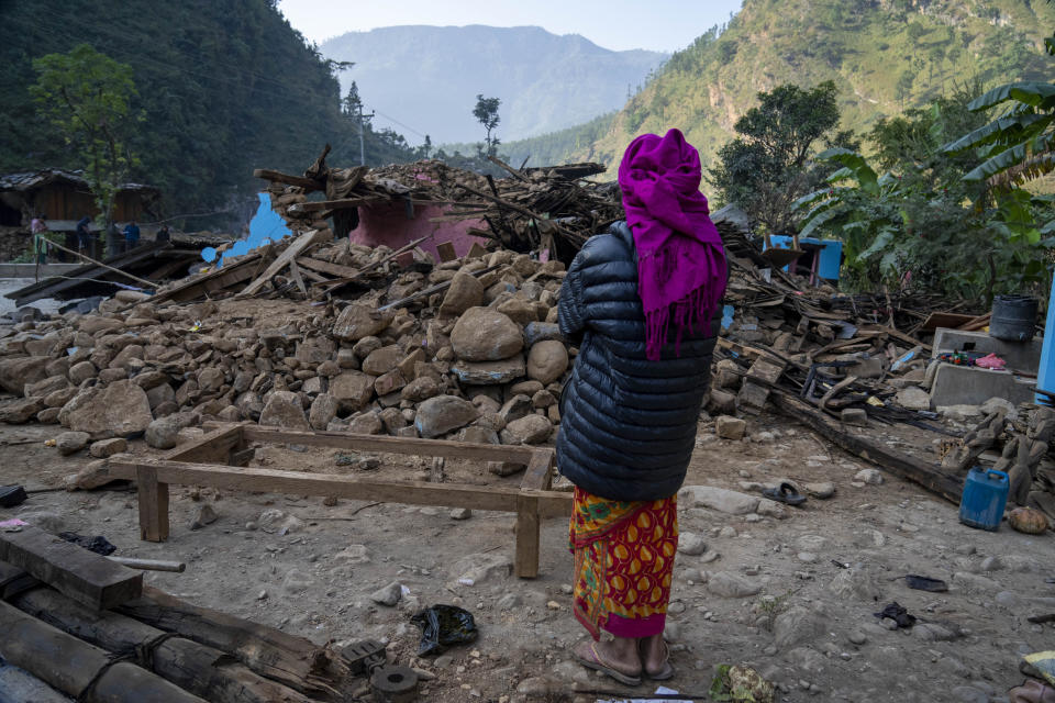A survivor looks at her earthquake damaged house in Rukum District, northwestern Nepal, Monday, Nov. 6, 2023. The Friday night earthquake in the mountains of northwest Nepal killed more than 150 people and left thousands homeless. (AP Photo/Niranjan Shrestha)
