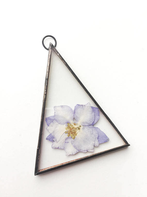 Get it from <a href="https://www.etsy.com/listing/579175666/glass-pressed-flower-frame-triangle?ga_order=most_relevant&amp;ga_search_type=all&amp;ga_view_type=gallery&amp;ga_search_query=real%20pressed%20flower%20wall%20hanging&amp;ref=sr_gallery-1-6" target="_blank">Paly Glass on Etsy, $14</a>.