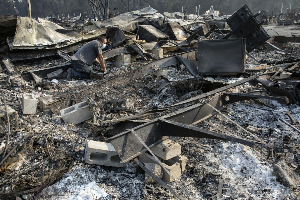 Jon Marshall looks through the debris of his home among the at Coleman Creek Estates mobile home park in Phoenix, Ore., Thursday, Sept. 10, 2020. The area was destroyed when a wildfire swept through on Tuesday, Sept. 8. The Marshalls lived at the park for 21 years. (AP Photo/Paula Bronstein)