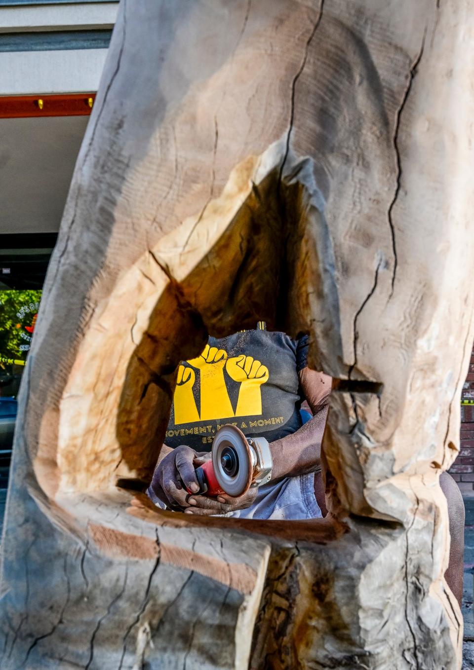 Buddy Jones carves on a tree trunk on Sept. 29 in Downtown Visalia.